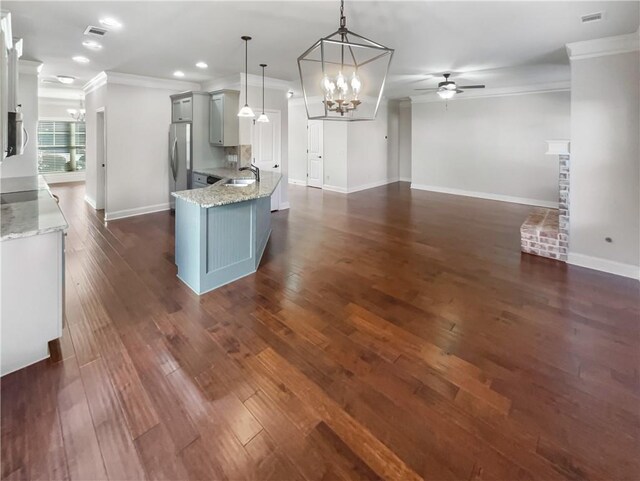 kitchen with ornamental molding, ceiling fan with notable chandelier, sink, decorative light fixtures, and stainless steel refrigerator