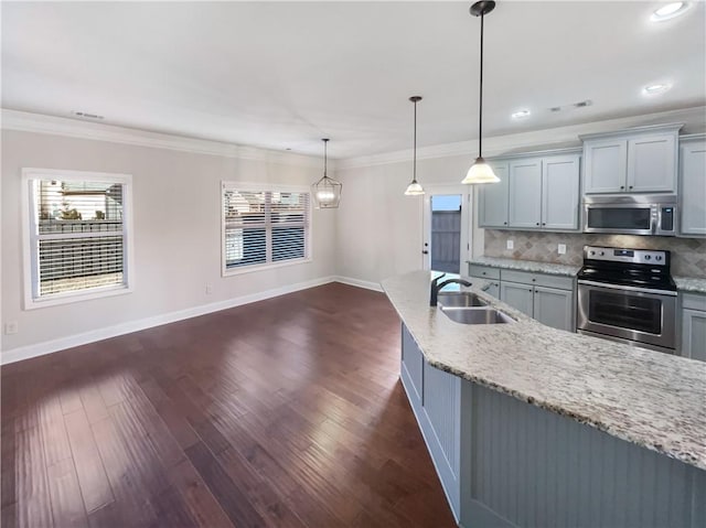 kitchen featuring light stone countertops, sink, pendant lighting, appliances with stainless steel finishes, and ornamental molding