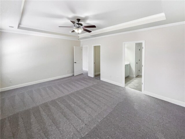 unfurnished bedroom featuring connected bathroom, a tray ceiling, ceiling fan, and light colored carpet