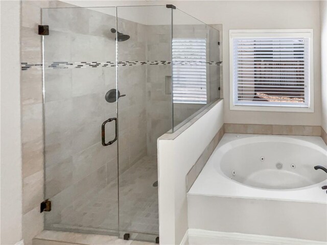 bathroom with plenty of natural light and independent shower and bath