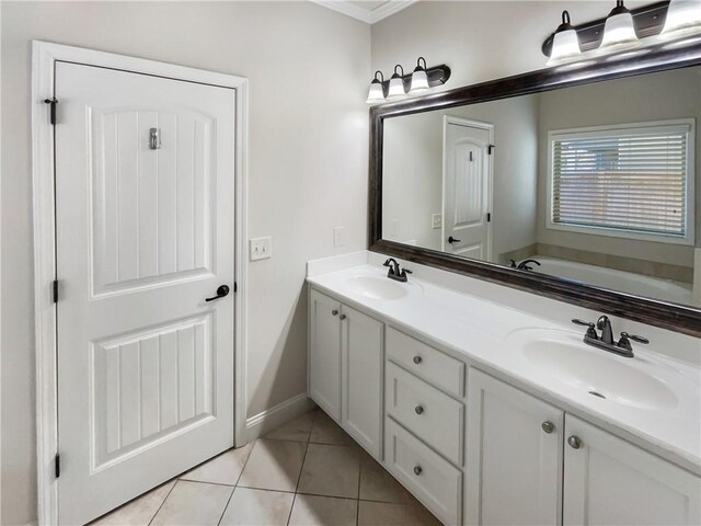 bathroom with a washtub, vanity, tile patterned floors, and crown molding