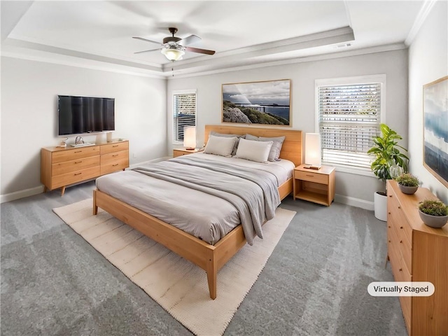 bedroom with a tray ceiling, ceiling fan, carpet floors, and ornamental molding