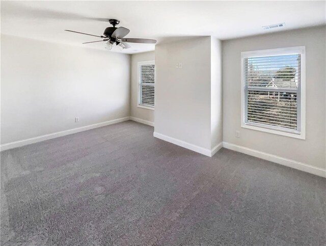 unfurnished room featuring ceiling fan and dark carpet