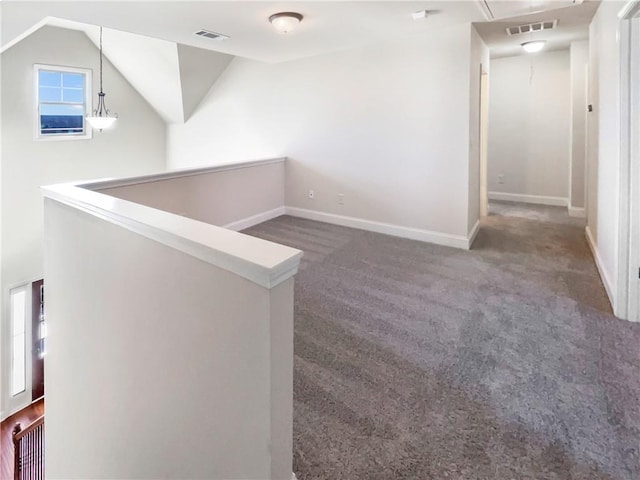 corridor featuring dark carpet and vaulted ceiling