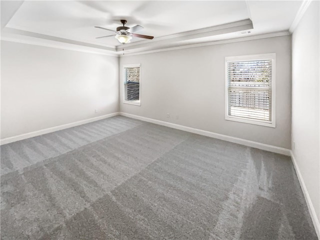 carpeted spare room featuring a tray ceiling, ceiling fan, and ornamental molding