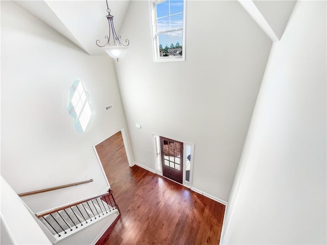 entryway featuring dark hardwood / wood-style flooring, high vaulted ceiling, and an inviting chandelier