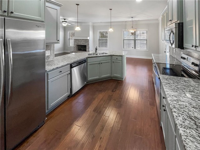 kitchen featuring backsplash, sink, light stone counters, and stainless steel appliances