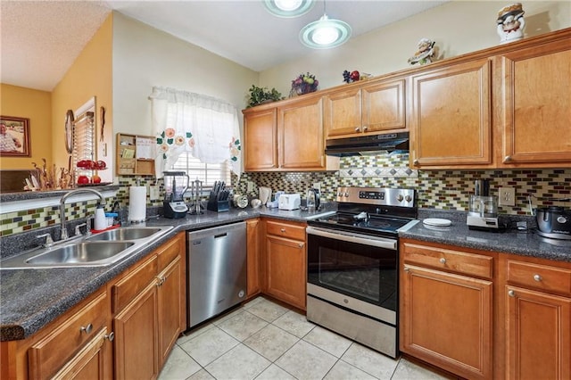 kitchen featuring sink, decorative backsplash, light tile patterned flooring, and appliances with stainless steel finishes