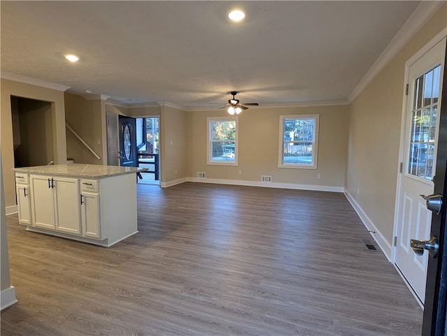 unfurnished living room with wood-type flooring, ceiling fan, and crown molding