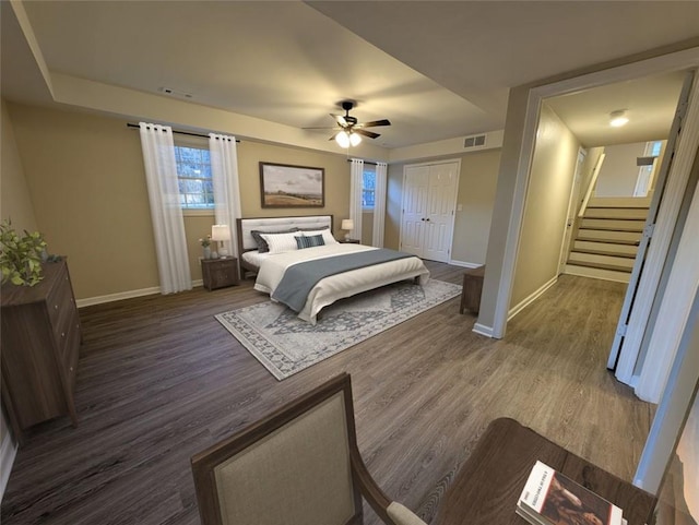 bedroom with ceiling fan, dark wood-type flooring, and a closet