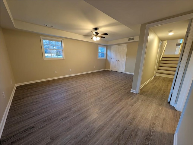 unfurnished bedroom with a closet, multiple windows, ceiling fan, and dark hardwood / wood-style flooring