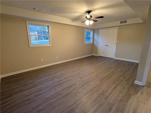 unfurnished bedroom with a closet, dark hardwood / wood-style floors, and ceiling fan