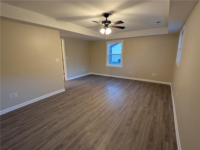 empty room with ceiling fan and dark hardwood / wood-style flooring