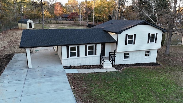 view of front of property with a front yard, a carport, and a storage shed