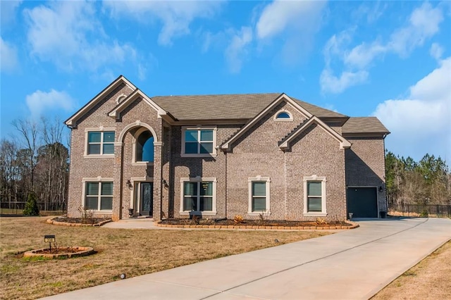 view of front of house featuring a garage, a front yard, brick siding, and driveway