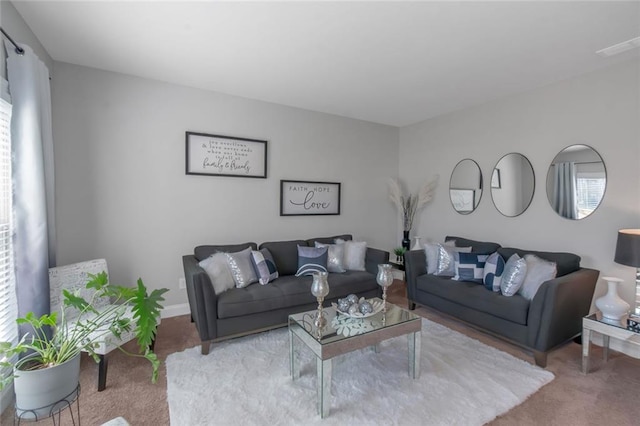 living area featuring visible vents, carpet flooring, and a wealth of natural light