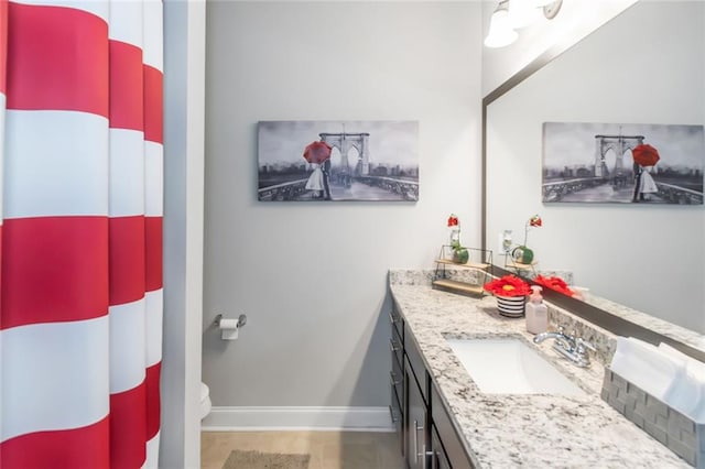 full bathroom featuring toilet, a shower with shower curtain, vanity, and baseboards