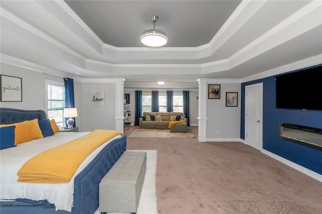 bedroom with baseboards, a tray ceiling, crown molding, carpet flooring, and ornate columns