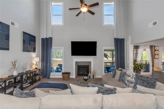 living area with a healthy amount of sunlight, visible vents, and a tiled fireplace