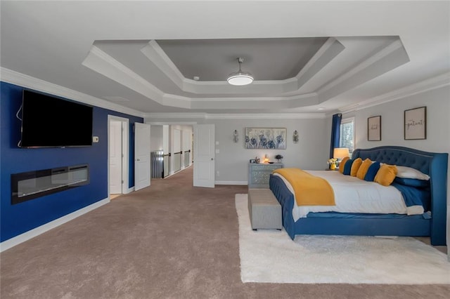 carpeted bedroom featuring ornamental molding, a tray ceiling, and baseboards