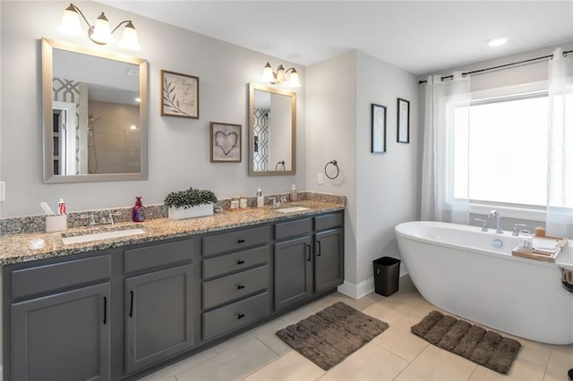 bathroom with double vanity, a freestanding tub, and a sink