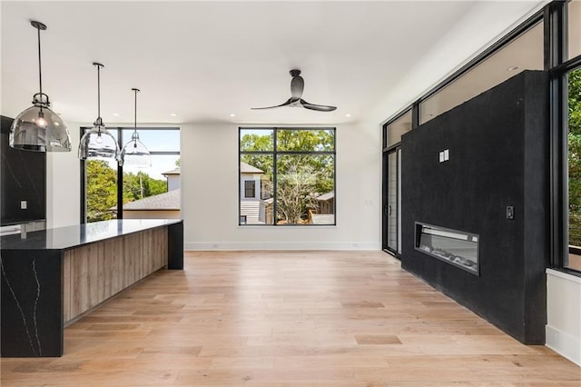 kitchen with a center island, ceiling fan, light hardwood / wood-style floors, and hanging light fixtures