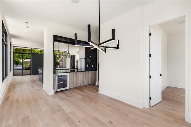 kitchen featuring a wall of windows, light hardwood / wood-style floors, and wine cooler