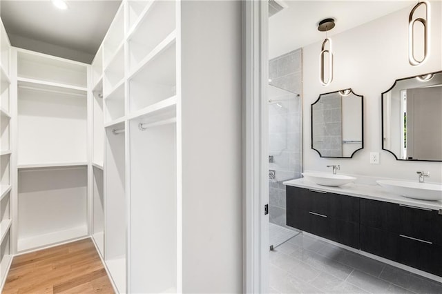 bathroom featuring vanity, a shower with shower door, and wood-type flooring