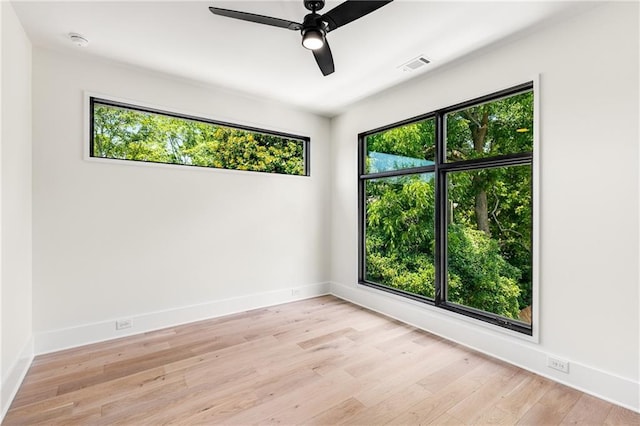 empty room with ceiling fan and light hardwood / wood-style flooring