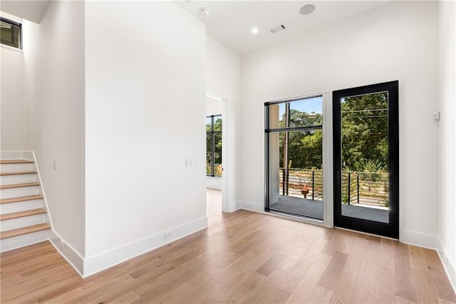 entryway featuring a high ceiling and light hardwood / wood-style flooring