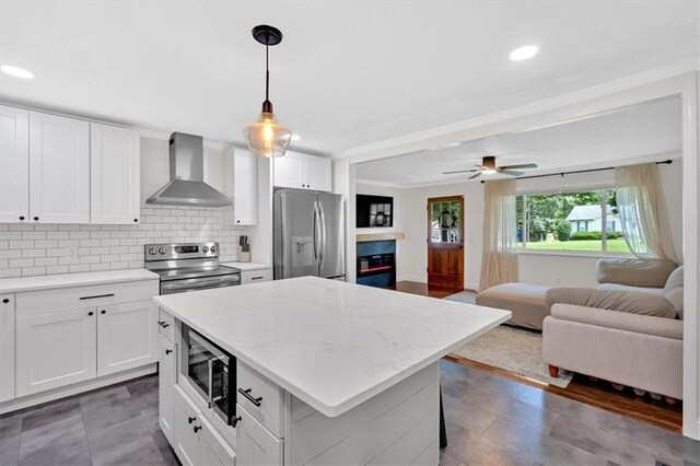 1162 Newtown Church Rd NE, Calhoun, GA 30701 - kitchen with appliances with stainless steel finishes, wall chimney range hood, open floor plan, a center island, and a glass covered fireplace