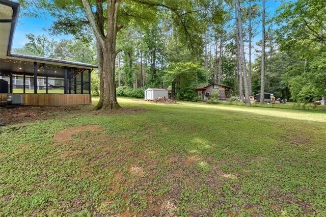 1162 Newtown Church Rd NE, Calhoun, GA 30701 - view of green lawn featuring a sunroom, a storage unit, and view of scattered trees
