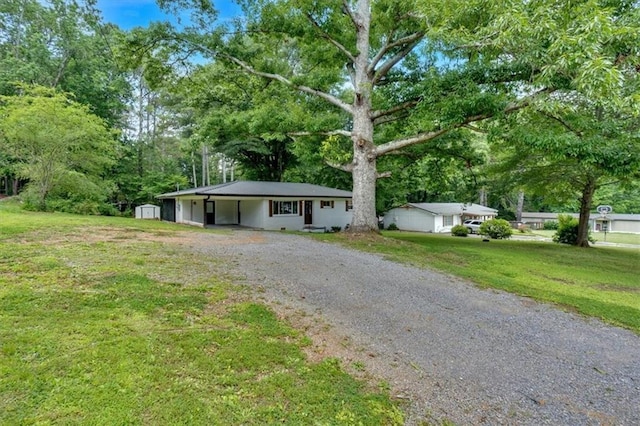 1162 Newtown Church Rd NE, Calhoun, GA 30701 - ranch-style home with driveway, a shed, a front yard, an attached carport, and view of scattered trees