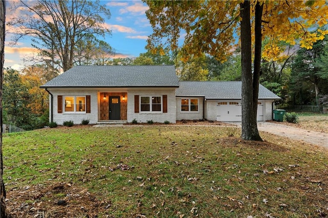 ranch-style home featuring a lawn and a garage