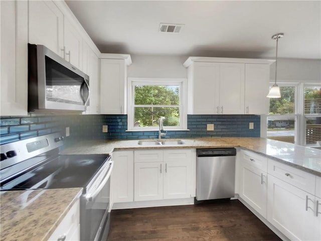 kitchen with white cabinetry, sink, stainless steel appliances, and hanging light fixtures