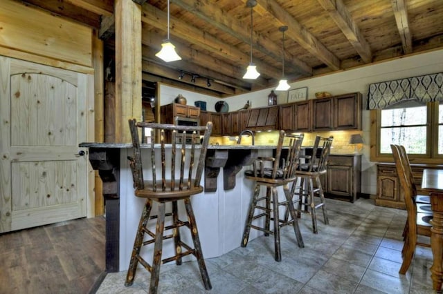 115 Coldwater Creek Dr, Mineral Bluff, GA 30559 - kitchen with a wooden ceiling with exposed beams, a breakfast bar, decorative light fixtures, and stainless steel microwave