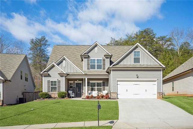 craftsman house featuring driveway, board and batten siding, and a front yard