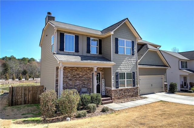 craftsman-style house featuring a chimney, board and batten siding, fence, stone siding, and driveway