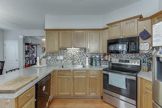 kitchen with tasteful backsplash, light countertops, a sink, and black appliances