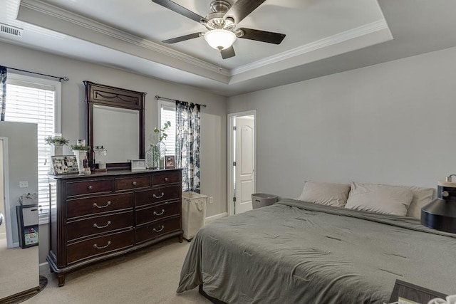 bedroom featuring a raised ceiling, light carpet, visible vents, and multiple windows