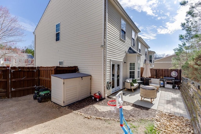 rear view of property featuring french doors, a patio area, and a fenced backyard