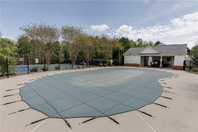 pool with a patio and fence