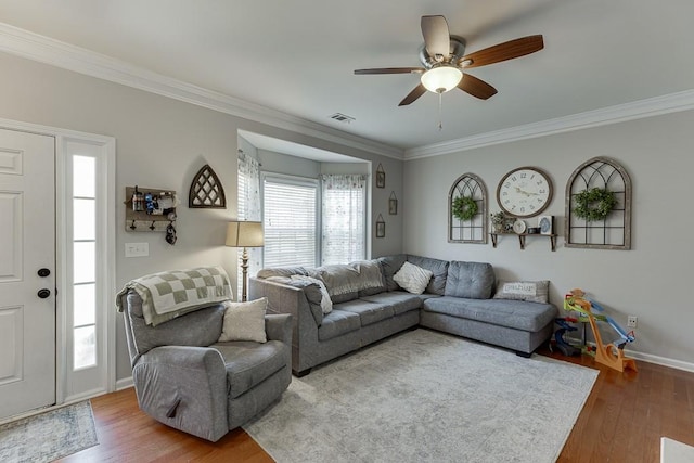 living room with ornamental molding, wood finished floors, and visible vents