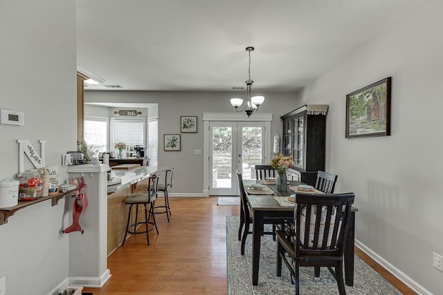 dining room with plenty of natural light, baseboards, wood finished floors, and french doors