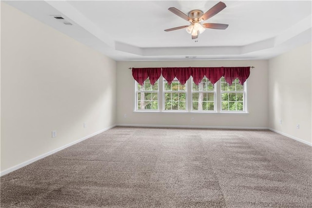 5312 Tormeal Trce, Suwanee, GA 30024 - carpeted empty room featuring a tray ceiling, healthy amount of natural light, and a ceiling fan
