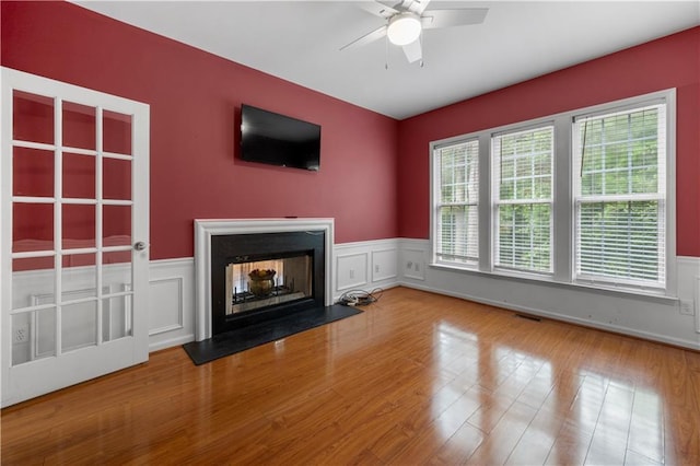 5312 Tormeal Trce, Suwanee, GA 30024 - unfurnished living room with ceiling fan, wainscoting, a fireplace, wood finished floors, and a decorative wall