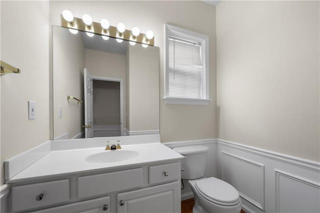 5312 Tormeal Trce, Suwanee, GA 30024 - bathroom featuring toilet, a wainscoted wall, vanity, and a decorative wall