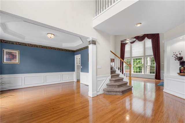 5312 Tormeal Trce, Suwanee, GA 30024 - empty room featuring decorative columns, a decorative wall, wood finished floors, stairway, and a wainscoted wall