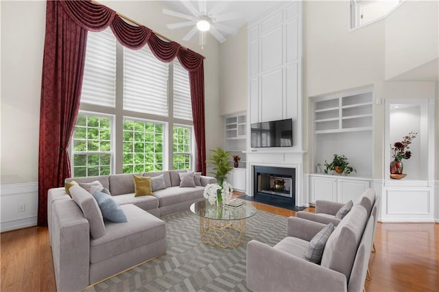 5312 Tormeal Trce, Suwanee, GA 30024 - living room with a ceiling fan, a high ceiling, wood finished floors, a fireplace, and built in features