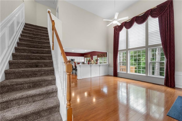 5312 Tormeal Trce, Suwanee, GA 30024 - stairs with wood finished floors, a high ceiling, ceiling fan, and a wainscoted wall